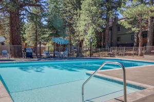 a swimming pool with chairs and an umbrella at The Summit 276 in Mammoth Lakes