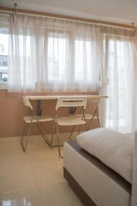 een slaapkamer met een bureau, een bed en een raam bij Kosmos Service Apartment Modern Spirit City Center With Additional Cost Parking in Thessaloniki