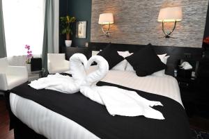 two swans are sitting on top of a bed at The Kings Arms Hotel in Berwick-Upon-Tweed