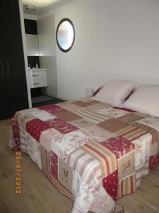 a bed with a quilt on it in a bedroom at Les Algues du Grau in Le Grau-dʼAgde