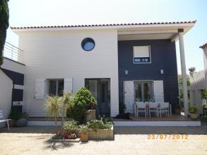 a blue and white house with a table and chairs at Les Algues du Grau in Le Grau-dʼAgde
