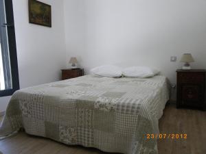 a bedroom with a bed with a blanket and two night stands at Les Algues du Grau in Le Grau-dʼAgde