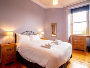 a bedroom with a large bed with towels on it at Pass the Keys Beautiful and Bright Georgian Style Morningside Apartment in Edinburgh