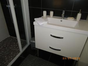 a bathroom with a white sink and a shower at Les Algues du Grau in Le Grau-dʼAgde