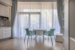a dining room with a table and chairs in front of a window at Mint Studio in Druskininkai
