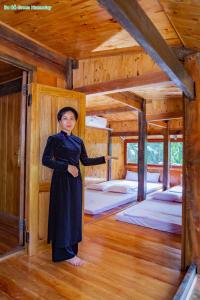 Ba Be Green Homestay في Bak Kan: امرأة تقف في غرفة في كابينة