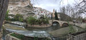 a bridge over a river in front of a mountain at La Cueva deLola in Alcalá del Júcar