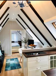 a kitchen with white cabinets and a ceiling with beams at Die Altstadt Appartements Caprice in Goslar