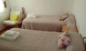 2 Betten in einem kleinen Zimmer mit einem Stuhl und einem Tisch in der Unterkunft Céntrico y luminoso San Vicente in Salamanca