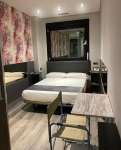 ウマネス・デ・マドリードにあるHotel Fabrikのベッドとテーブルと椅子のあるホテルの部屋