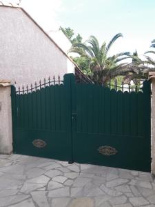 a green gate in front of a house at Les Algues du Grau in Le Grau-dʼAgde