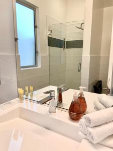 a white bathroom with a sink and a mirror at Anchor Inn Pacifica in Pacifica