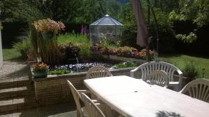 a table and chairs in a garden with flowers at LA CONTAMINE in Nâves-Parmelan