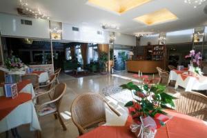 a dining room with tables and chairs in a restaurant at Hotel Villa Mulino ***S in Garda