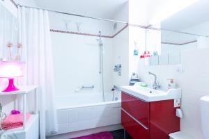 a bathroom with a white tub and a red cabinet at Deutsche Messe Zimmer - Private Apartments & Rooms Hannover City - room agency in Hannover