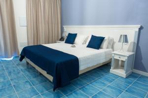 1 dormitorio con 1 cama grande, paredes azules y suelo de baldosa azul en Galìa Luxury Resort, en Pizzo