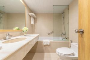 a bathroom with a sink and a toilet and a tub at Hanoi Hotel in Hanoi