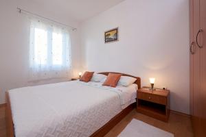 - une chambre avec un lit blanc et une fenêtre dans l'établissement Apartment Ivanka - 200 m from sea, à Trogir