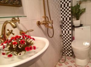 un baño con lavabo con flores rojas. en Melody home, en Hanói