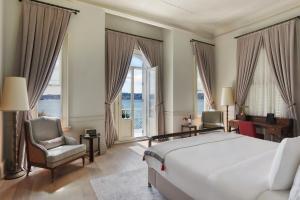 sypialnia z łóżkiem, krzesłem i oknami w obiekcie Six Senses Kocatas Mansions w Stambule