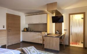 a kitchen with a table and a kitchen with white cabinets at Appartements Pfister in Fügen