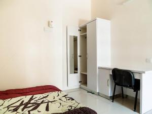 a bedroom with a bed and a desk and a chair at Kampar Private Roomstay W in Kampar