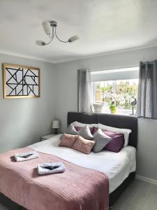 ein Schlafzimmer mit einem großen Bett mit einer rosa Decke in der Unterkunft Comfortable rooms in the house in Oxford
