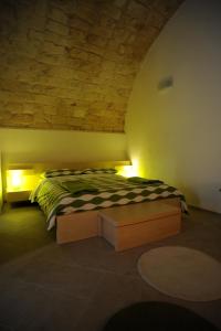 a bedroom with a bed and lights on the wall at Siqillya in Ragusa