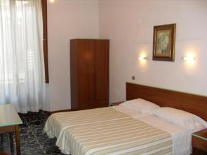 フィレンツェにあるマリーズ ハウスのベッドとキャビネット付きのホテルルーム