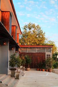 a house with a wooden garage with potted plants at Boutique Family Room Phitsanulok in Phitsanulok