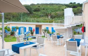 a patio with tables and chairs and a staircase at Galìa Luxury Resort in Pizzo