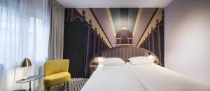 Hotel Hubert Grand Place في بروكسل: غرفة نوم بسرير وكرسي اصفر