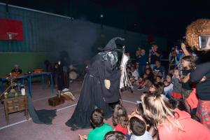 una persona vestida de bruja parada frente a una multitud en Camping Baltar, en Portonovo