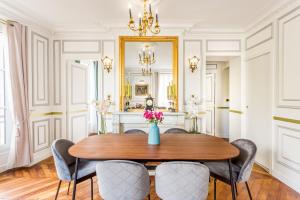 een eetkamer met een tafel en stoelen en een spiegel bij Luxury 2 Bedroom With Balcony - Louvre & Notre Dame in Parijs