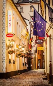 a street with flags and a flag on a building at Old Riga Boutique Hotel "Vecriga" in Rīga