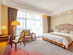a large hotel room with a bed and a desk and a desk at Binhai Jinling International Hotel in Binhai +39 photos