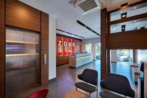 a lobby with two chairs and a zoya store at ZONE Hotels, Telok Panglima Garang in Teluk Panglima Garang