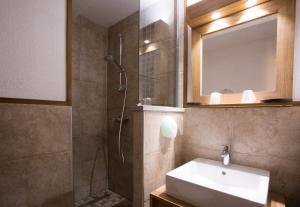 La salle de bains est pourvue d'une douche, d'un lavabo et d'un miroir. dans l'établissement Hôtel L'Echaillon, à Névache