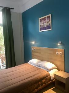 a bedroom with a bed with a blue wall at Hotel Kastoria in Thessaloniki