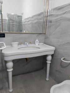 Casalbergo700 في مارينا دي فوسكالدو: حمام مع حوض أبيض ومرآة