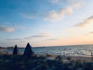 a beach with a view of the ocean at sunset at ApartamentLeśna12Hel in Hel