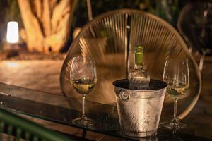 una bottiglia di vino in un secchio su un tavolo con due bicchieri di Suítes no Quintal a Brotas