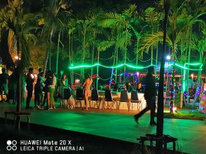 een groep mensen die 's nachts op een podium staan bij RS Phong Riverside Resort in Khon Kaen
