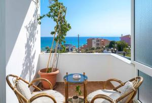 d'une terrasse avec 2 chaises et une table sur un balcon. dans l'établissement Villa Golden Nest, à Limenaria