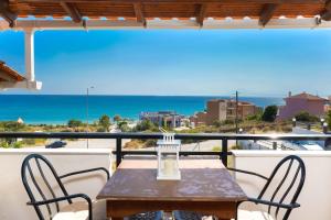 d'une table et de chaises sur un balcon avec vue sur l'océan. dans l'établissement Villa Golden Nest, à Limenaria