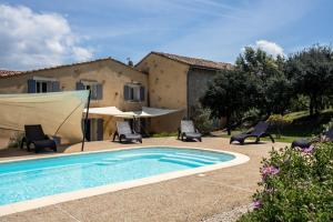 a swimming pool in front of a house at Clos Saint-Michel Resort & Spa in Malaucène
