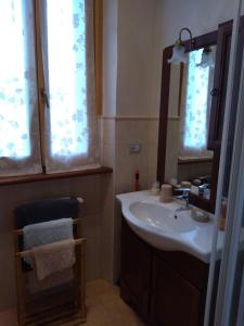 W łazience znajduje się umywalka i lustro. w obiekcie Il Nido del Cuculo w mieście Petrignano