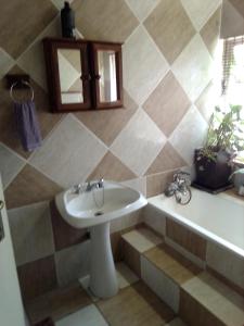 een badkamer met een wastafel en een bad bij ADS Overnight Accommodation in Richards Bay