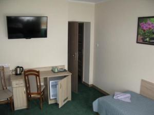 Pokój hotelowy z biurkiem, łóżkiem, biurkiem i krzesłem w obiekcie Willa Sole w Busku Zdroju