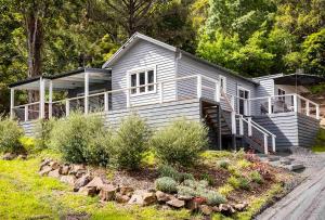 a white house with a porch and a yard at Warburton Digs in Warburton